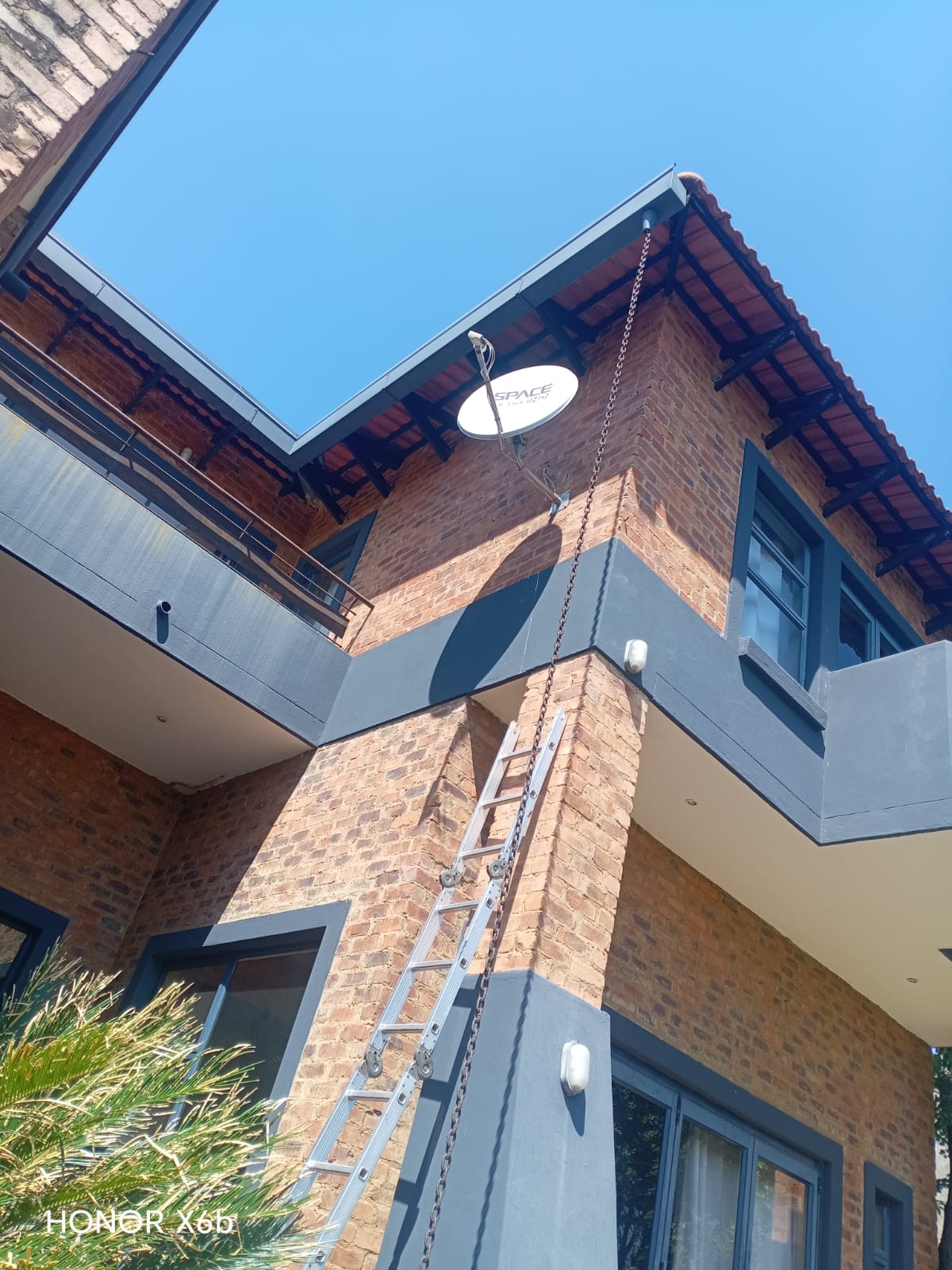 Technician installing DStv on a double-storey Durbanville home